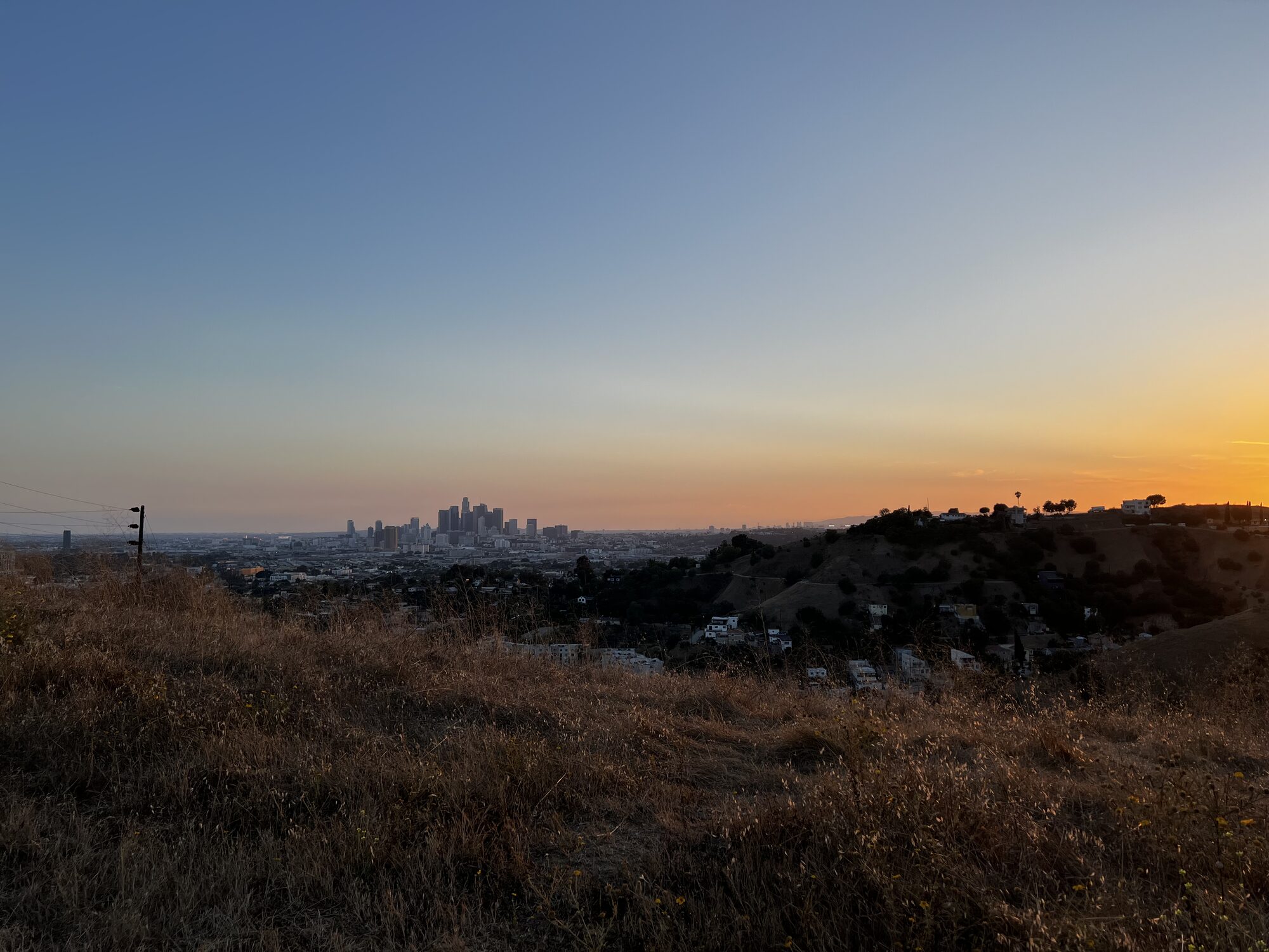 The Otero Drive lot at sunset with the downtown skyline behind.